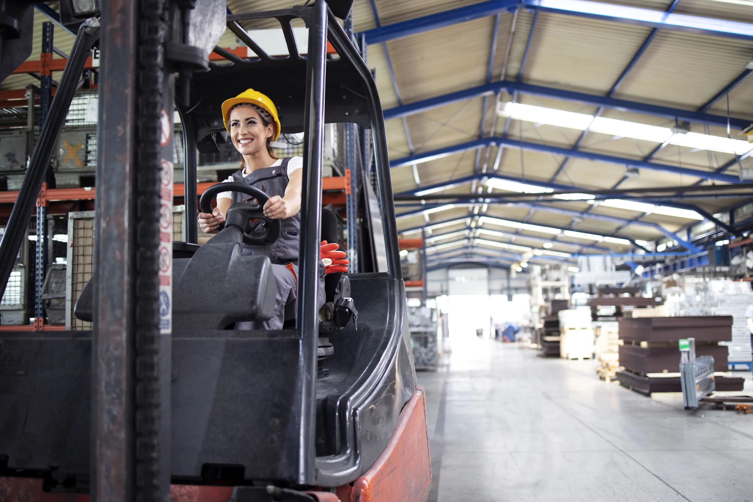 Mulher sorridente em um centro logístico, representando sucesso em soluções logísticas