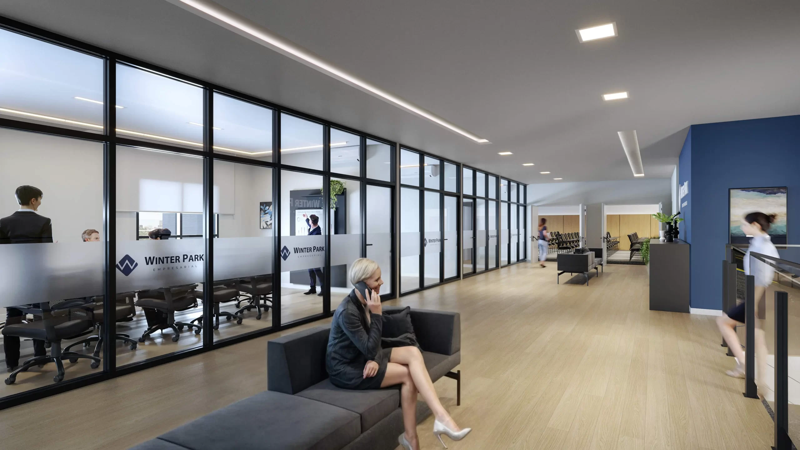 Interior moderno de um condomínio empresarial com salas de reunião envidraçadas e áreas de convivência, ilustrando como esses espaços colaborativos podem ajudar empresas a reduzir custos operacionais.