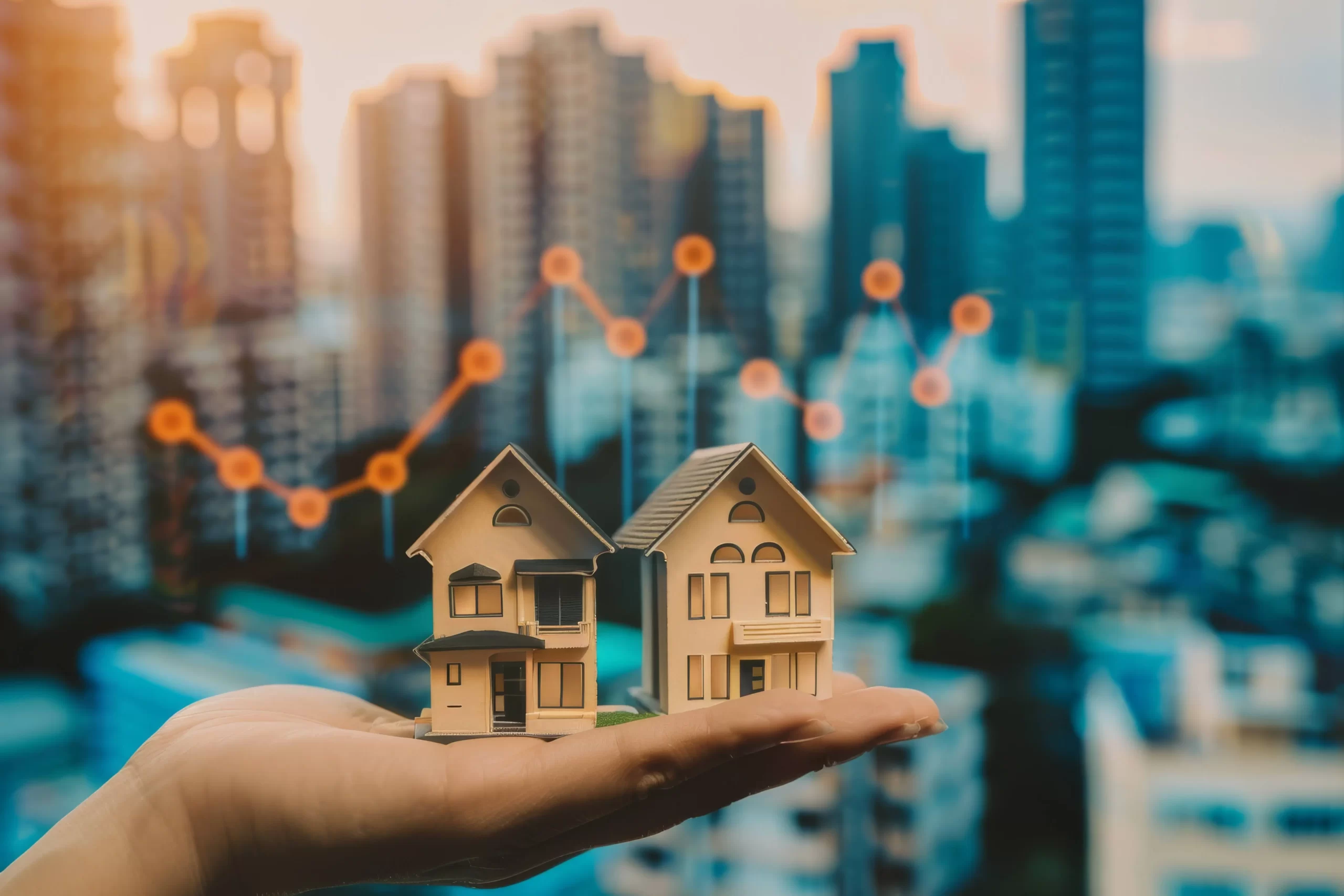 Pessoa segurando duas miniaturas de casas com gráfico de dados ao fundo, representando as tendências do mercado imobiliário em áreas urbanas.